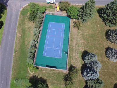 Outdoor sports court with a blue and green surface, featuring basketball hoops and multiple court markings in Shoreview.