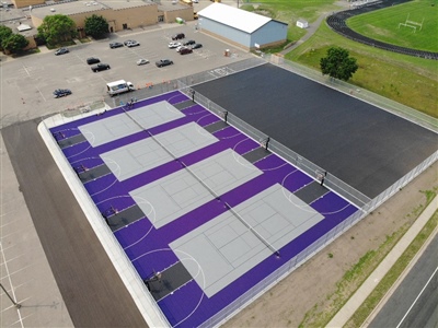 Purple outdoor recreation courts featuring multiple grey basketball and tennis courts in Arden Hills. 