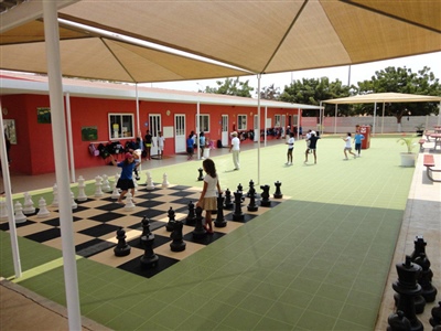 Multipurpose outdoor sport court with green flooring and giant chess board in Mendota Heights.